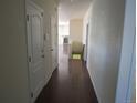 A hallway with wood floors, light walls, and white doors leads to a bright living space at 3212 S Kirk Way, Aurora, CO 80013