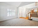 Open-concept living area featuring shuttered windows and a staircase at 11969 E Lake Cir, Greenwood Village, CO 80111
