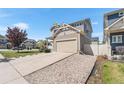 Charming home featuring a two-car garage, driveway, gravel landscaping, and well-maintained lawn at 4405 Walden Ct, Denver, CO 80249