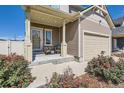 Welcoming front porch with seating, complemented by beautiful flowerbeds and a well-manicured lawn at 4405 Walden Ct, Denver, CO 80249