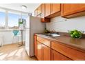 Cozy kitchenette featuring warm wood cabinetry, a compact refrigerator, and bright natural light at 1196 N Grant St # 405, Denver, CO 80203