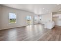 Bright and airy living room features wood floors, recessed lighting and sliding glass doors to backyard at 2177 Flower Blossom Ave, Brighton, CO 80601