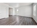 Spacious room with wood floors, white walls, natural light, and two white doors at 2177 Flower Blossom Ave, Brighton, CO 80601