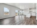 Open-concept living room boasts natural light and hard wood floors, creating an airy and welcoming space at 2177 Flower Blossom Ave, Brighton, CO 80601