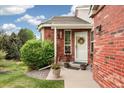 Inviting front entrance with red brick, a wreath, and decorative potted plants at 9441 Southern Hills Cir, Lone Tree, CO 80124