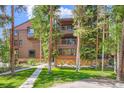 Multi-story home with wood siding and balconies, surrounded by lush greenery and a well-maintained lawn at 180 Broken Lance Dr # 14, Breckenridge, CO 80424
