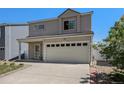 Traditional two-story home features a two-car garage, a well-manicured lawn, and a cozy front porch at 4076 Andes Way, Denver, CO 80249