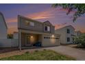 Charming two-story home with a well-maintained lawn and two-car garage under a beautiful sunset sky at 4076 Andes Way, Denver, CO 80249