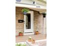 Inviting front porch with brick facade, hanging plants, and potted flowers that add to the home's curb appeal at 3005 Grove St, Denver, CO 80211