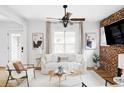 Bright living room with white walls, hardwood floors, a cozy couch, and a decorative brick wall at 3005 Grove St, Denver, CO 80211