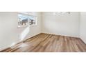 Bright, airy bedroom with hardwood floors and a large window offering neighborhood views at 27684 E Byers Ave, Aurora, CO 80018
