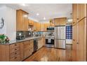 Well-lit kitchen with stainless steel appliances, wooden cabinets, and granite countertops at 2084 Bell Ct, Lakewood, CO 80215