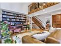 Inviting living room with a soaring ceiling, a cozy fireplace, a built-in bookcase, and stylish decor at 23646 Genesee Village Rd, Golden, CO 80401
