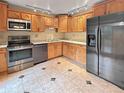 Functional kitchen featuring stainless steel appliances and warm oak cabinetry at 9236 W Euclid Ave, Littleton, CO 80123