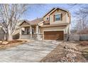 Inviting two-story home featuring a long driveway, warm siding, and a cozy front porch with stone accents at 6485 Silverleaf Ave, Firestone, CO 80504