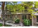 Inviting townhouse exterior with brick facade, mature trees, and a private second-story balcony at 7589 S Cove Cir, Centennial, CO 80122