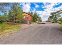 Rustic log home with gravel driveway and ample parking space at 1353 S Elbert St, Elizabeth, CO 80107