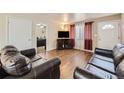 Bright living room with hardwood floors, comfortable leather sofas, and ample natural light at 465 Miller Ave, Brighton, CO 80601