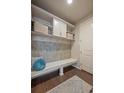 Well-appointed mudroom featuring tiled backsplash, built-in storage, bench, and coat hooks at 3336 Goodyear St, Castle Rock, CO 80109
