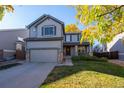 Two-story house with gray siding, attached garage, and landscaped yard at 3929 S Quemoy Ct, Aurora, CO 80018