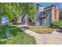 Apartment building exterior with well-maintained lawn and pet waste station by a walkway at 7897 Allison Way # 304, Arvada, CO 80005