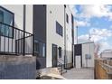 Modern home exterior featuring black and white paint, well maintained landscaping, and concrete path to back door at 1252 Yates St, Denver, CO 80204