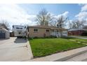 A charming one-story brick house with a well-kept lawn and an RV on the driveway at 6705 Nelson St, Arvada, CO 80004