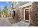 The entrance features a warm, inviting brown door and stone accents for a cozy and charming welcome at 12832 Mayfair Way # A, Englewood, CO 80112