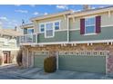 A lovely view of the home with stone accents, charming windows, and individual garage spaces at 12832 Mayfair Way # A, Englewood, CO 80112