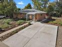 Ranch style home with a large driveway and well-manicured landscaping at 3045 Xanadu St, Aurora, CO 80011