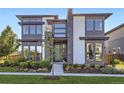 Modern two-story home featuring a combination of gray siding, white brick accents, and large windows at 6005 Beeler St, Denver, CO 80238