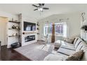 Bright living room with fireplace, hardwood floors, vaulted ceiling, and abundant natural light at 1421 Rustic Dr, Longmont, CO 80504