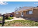 Well-maintained front yard with steps leading to a charming brick home and decorative door at 5519 Tucson St, Denver, CO 80239