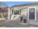 Close-up of gray brick house, black shutters and metal railings, with a small garden area at 2555 Hudson St, Denver, CO 80207