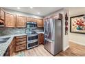 Modern kitchen featuring stainless steel appliances, wood cabinets, and tile backsplash at 3022 S Wheeling S Way # 410, Aurora, CO 80014