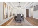 Elegant dining room with stylish chandelier, tray ceilings, and decorative wall art at 34 Sommerset Cir, Englewood, CO 80111
