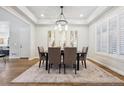 Bright dining room featuring a stylish chandelier, tray ceiling, and shuttered windows at 34 Sommerset Cir, Englewood, CO 80111