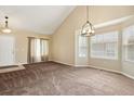 Bright living room featuring neutral carpet, vaulted ceiling, and ample natural light streaming through large windows at 4713 S Ireland St, Aurora, CO 80015