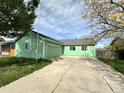 A charming single-story green home with an attached garage and front yard at 780 2Nd St, Bennett, CO 80102