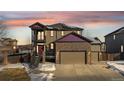 Two-story house with stone accents, a two-car garage, and a balcony at 9066 Sandpiper Dr, Frederick, CO 80504