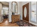 Bright entryway with hardwood floors, mirror, and storage console at 8656 Aberdeen Cir, Highlands Ranch, CO 80130