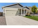 Inviting home featuring a spacious driveway, two-car garage and stone accents on the exterior at 47341 Lily Ave, Bennett, CO 80102