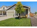 This single-Gathering home boasts a two-car garage, manicured lawn, and charming stone veneer accents at 47341 Lily Ave, Bennett, CO 80102