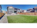 Large backyard featuring a cozy seating area, outdoor dining, and lush artificial turf at 9095 Birch Run Ln, Parker, CO 80134