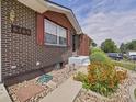 Close-up of a brick home's entry showcasing stone landscaping and a cozy, inviting entrance at 6769 W 70Th Ave, Arvada, CO 80003