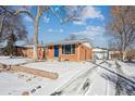 Ranch home with a snow-covered yard, visible driveway, and garage at 3345 W Aqueduct Ave, Littleton, CO 80123