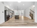Open-concept kitchen and living area with gray cabinets, stainless appliances, and hardwood floors at 2347 Kite Route Ln, Superior, CO 80027