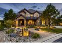 Elegant two-story home with stone facade and a water feature at 10887 Rainribbon Rd, Highlands Ranch, CO 80126