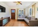 Cozy living room with hardwood floors, a gray sectional sofa, and a classic television set at 45 S Grove St, Denver, CO 80219
