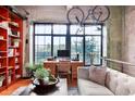 Comfortable living room with large windows, modern furniture, hardwood floors, and a unique bicycle decoration at 2000 Little Raven St # 1B, Denver, CO 80202